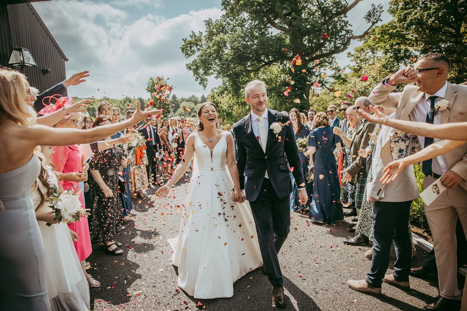 Wedding couple walking through a confetti shower at Cabra Castle